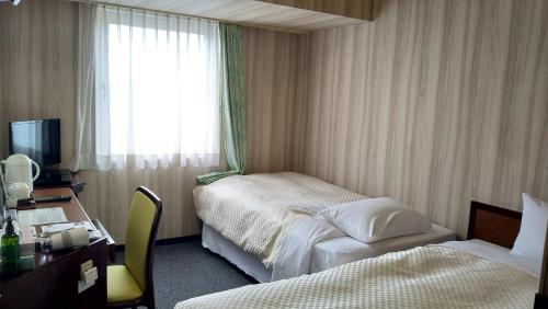 大馆市大馆皇家酒店的酒店客房设有两张床、一张书桌和一个窗户。