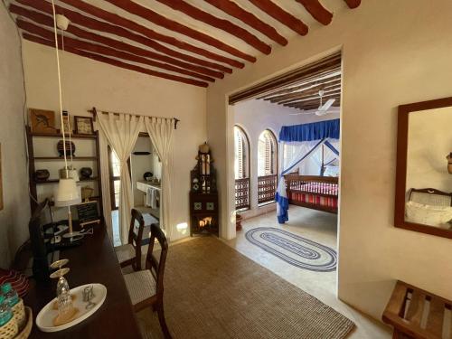 拉穆Authentic Swahili style villa Milele House的一间带桌椅的客厅和一间房间