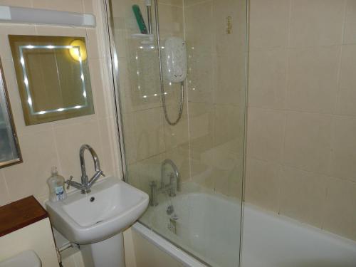 爱丁堡1 Bedroom Flat in Historic Cooperage Apartments Leith的带淋浴、盥洗盆和浴缸的浴室
