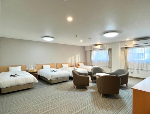 山中湖村富士山中湖森普莱斯酒店的酒店客房,配有三张床和椅子