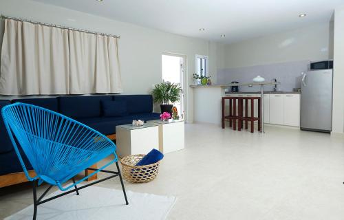 El YaquePosada Buena Vista Beach Club的一间带蓝色沙发的客厅和一间厨房