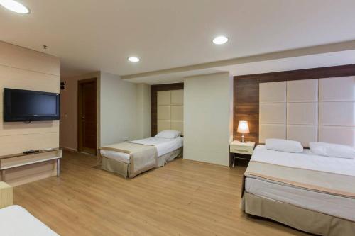 伊斯坦布尔Derpa Hotel的酒店客房设有两张床和一台平面电视。