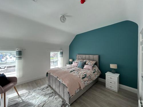 斯尼姆Sneem Studios的一间卧室配有一张蓝色墙壁的床