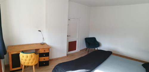 圣尼古拉Chambre cosy的一间卧室配有一张床、一张桌子和一把椅子