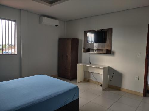 里约布兰科Residencial Isaura的一间卧室配有一张床、一张书桌和一台电视。