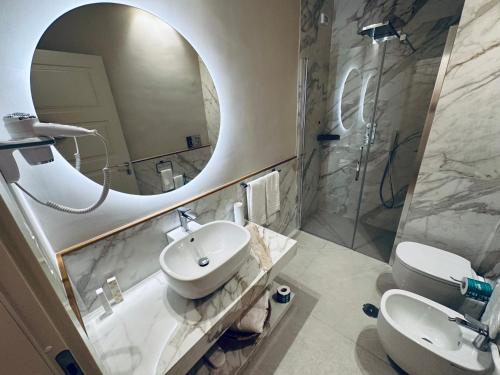 比谢列Palazzo Bonomi的一间带水槽、镜子和卫生间的浴室