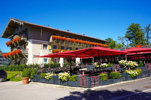 基姆湖畔普林基姆湖斯加洛斯布里克酒店的大楼前的一间餐厅,配有红色遮阳伞