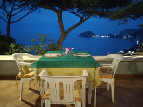 伊斯基亚Hotel Villa al Mare的一张桌子和椅子,享有海景