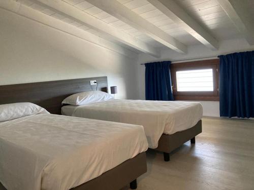 利莫内-苏尔加达La Casa sul Lago Apartments - Olive Tree Apartment的酒店客房设有两张床和窗户。