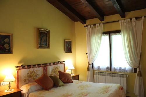 ElosuAgroturismo Atxarmin的一间卧室配有一张带两盏灯的床和一扇窗户。