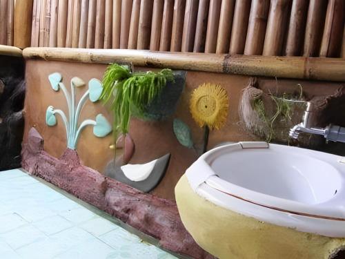 武吉拉旺back to nature ecotourism的一间带卫生间的浴室和墙上的绘画