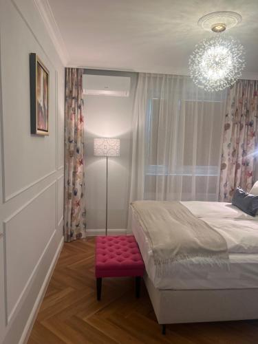 拉多姆Bella Casa Luxury Apartament的一间卧室配有一张床和红色凳子