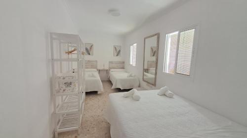 塞维利亚Apartamentos TrianaSol的白色的客房设有两张床和梯子