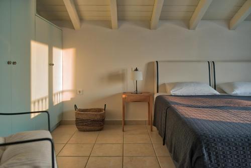 蒂锡利维Erietta Aparthotel的一间卧室配有两张床和一张带台灯的桌子