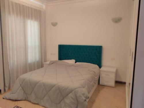 沙姆沙伊赫شقة غرفتين وصاله ومطبخ وحمام مفروش كامل سوبر لوكس的一间卧室配有一张带绿色床头板的床