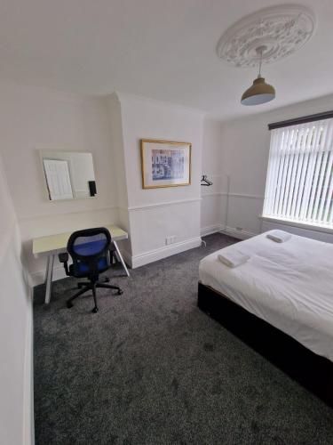 盖茨黑德Luna Apartments Newcastle Gateshead 1的一间卧室配有一张床、一张桌子和一把椅子
