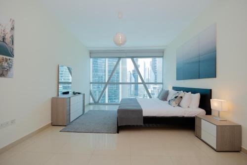 迪拜Newly furnished, spacious and modern 1BR in DIFC的一间卧室设有一张床和一个大窗户