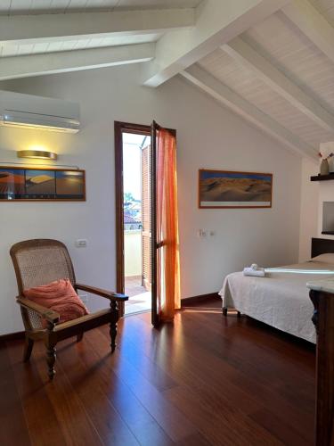 圣温琴佐Bougainville的卧室配有床、椅子和窗户。