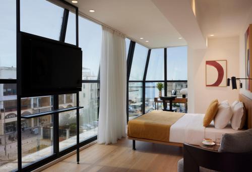 塞萨洛尼基Noa Hotel的一间卧室配有一张床和一台平面电视