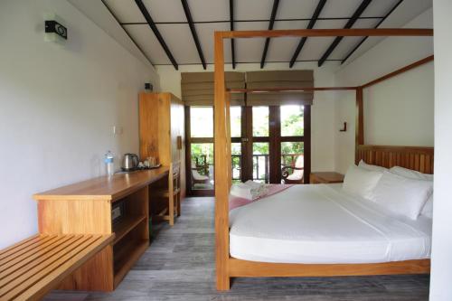 米瑞莎Handagedara Resort & Spa的一间卧室配有一张床和一张书桌