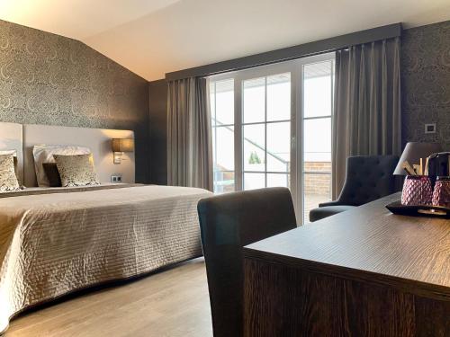奥斯坦德Charmehotel Kruishof的一间卧室配有一张床、一张书桌和一个窗户。
