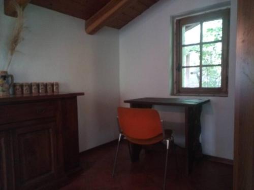 Villar PelliceL'ontano sulle Alpi的客房设有桌子、椅子和窗户。