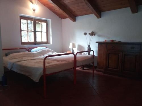 Villar PelliceL'ontano sulle Alpi的一间卧室配有一张带窗户和桌子的床