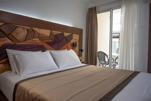 MacouriaHôtel Belle Terre Resort的一间带大床的卧室和一个阳台