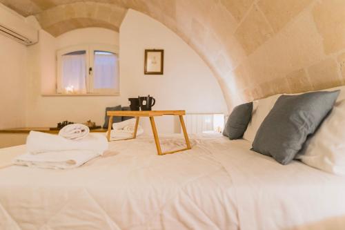马泰拉[Sassi-Suite]- Aura - Matera的卧室配有一张白色的床和一张桌子