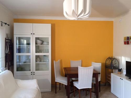 沙尔内卡Caparica Holidays的一间带桌子和白色椅子的用餐室