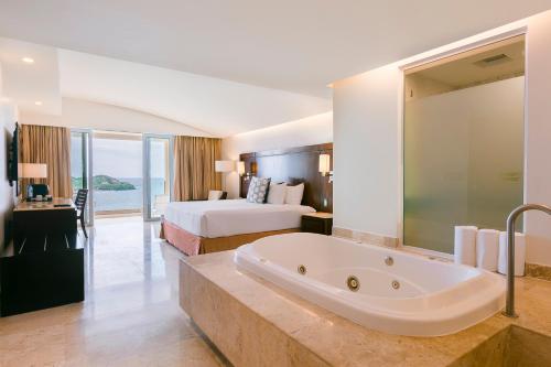 伊斯塔帕阿祖尔伊斯塔帕豪华全包式套房酒店 - 温泉及会议中心的酒店客房配有一张床和浴缸。
