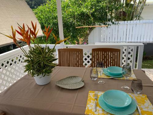 帕皮提Fare Manatea 19的棕色的桌子,上面有盘子和玻璃杯,还有植物