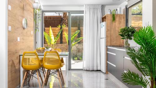 埃拉特By Eezy - אורה דירות אירוח的厨房配有黄色椅子和桌子
