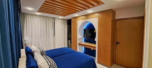拉巴特RABAT RESIDENCE - rooms的一间卧室配有蓝色的床和电视