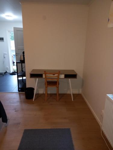 EnkärretEasystar guest house的一张桌子,位于带椅子的房间的角落