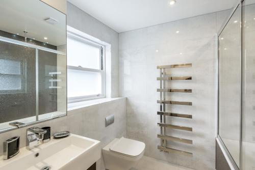 伦敦肯辛顿高街公寓的一间带卫生间、水槽和窗户的浴室