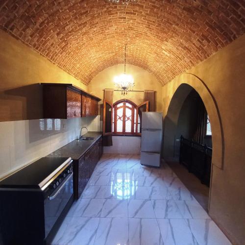 卢克索Mystical habou domes villa的厨房设有拱门和砖墙
