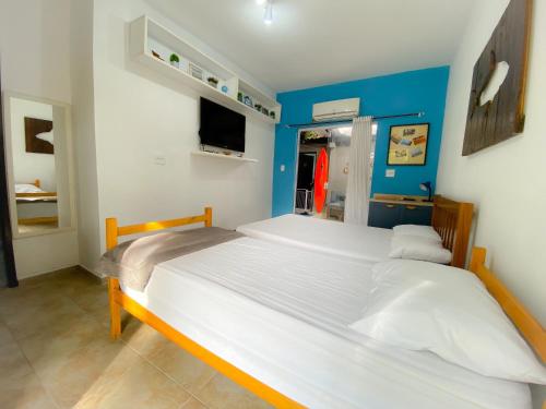伯迪亚哥SUÍTE PRIVATIVA RIVIERA & ITAGUARÉ 100mts de 2 praias!的卧室设有两张床铺,拥有蓝色的墙壁