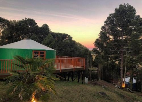 圣若阿金Solar do Oriente - Yurt Ecovillage的一座带甲板和树的绿色房子