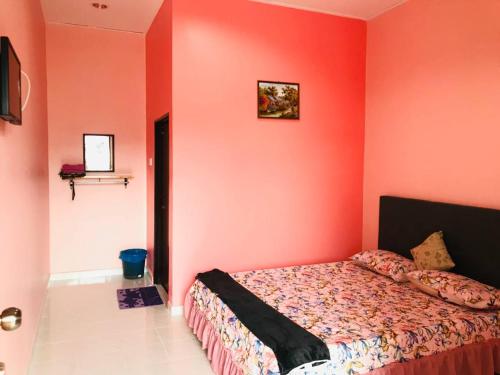 Kampong Balai MarasChalet Sri Bayu的卧室设有红色的墙壁和一张床