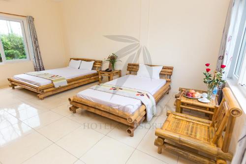 Hưng LongTre Nguồn Thiên Cầm Hotel&Resort的一间卧室配有两张床和一张鲜花桌