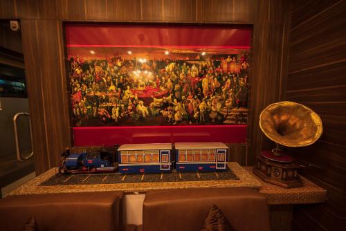 西里古里Rajdarbar Hotel & Banquet, Siliguri的画前桌子上的玩具火车