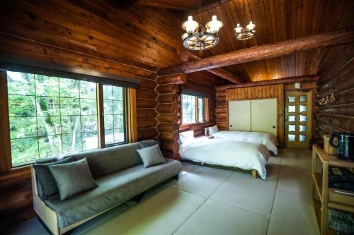 日光Hacho no Yu的带沙发、床和窗户的客厅