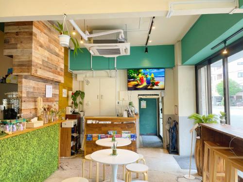 东京STAY WORK ASAKUSA guest house 浅草店的餐厅设有两张桌子和一台墙上的电视