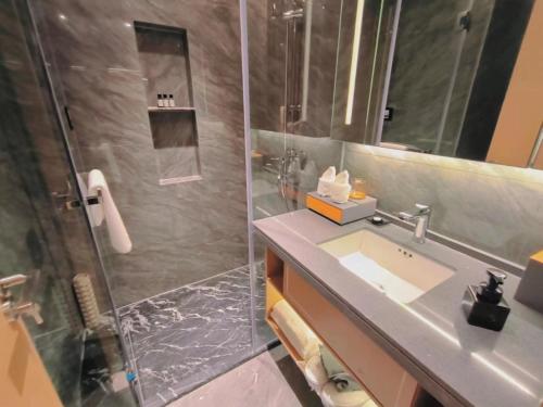 东莞Shi Lai De Executive Apartments的带淋浴、盥洗盆和淋浴的浴室