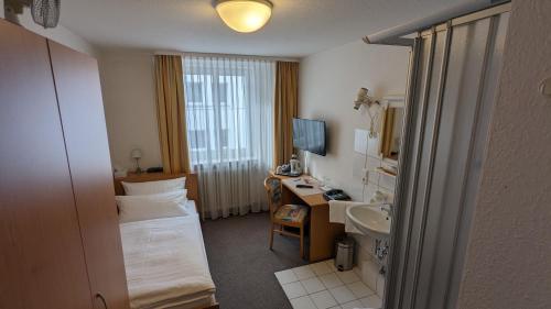 斯图加特齐格勒加特豪斯酒店的酒店客房配有床、书桌和水槽