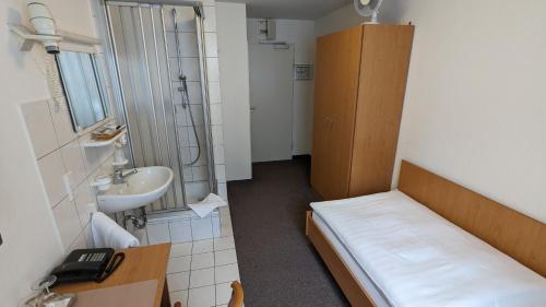 斯图加特齐格勒加特豪斯酒店的小房间设有床和水槽