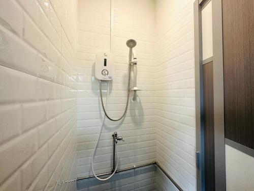 新加坡THE ROOM Capsule Hotel的白色浴室设有淋浴和软管