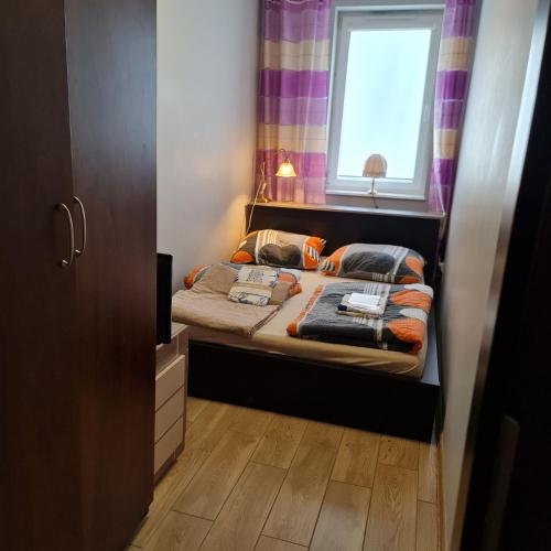 米兹多洛杰Apartament Międzyzdroje 4 osoby - 100 m od morza的一间小卧室,配有床和窗户