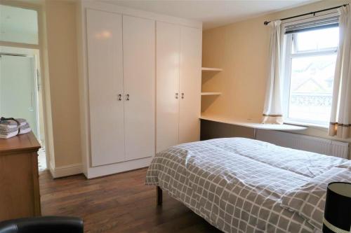 Thamesmead2 Bedroom cosy stay in Barking的一间卧室设有一张床和一个窗口